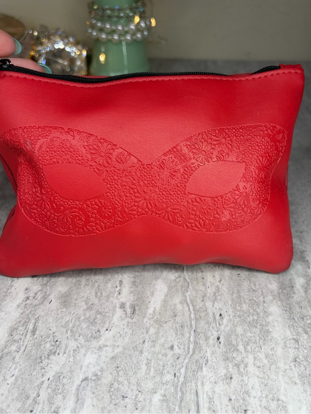 Red makeup cosmetic bag filled with wearable jewelry